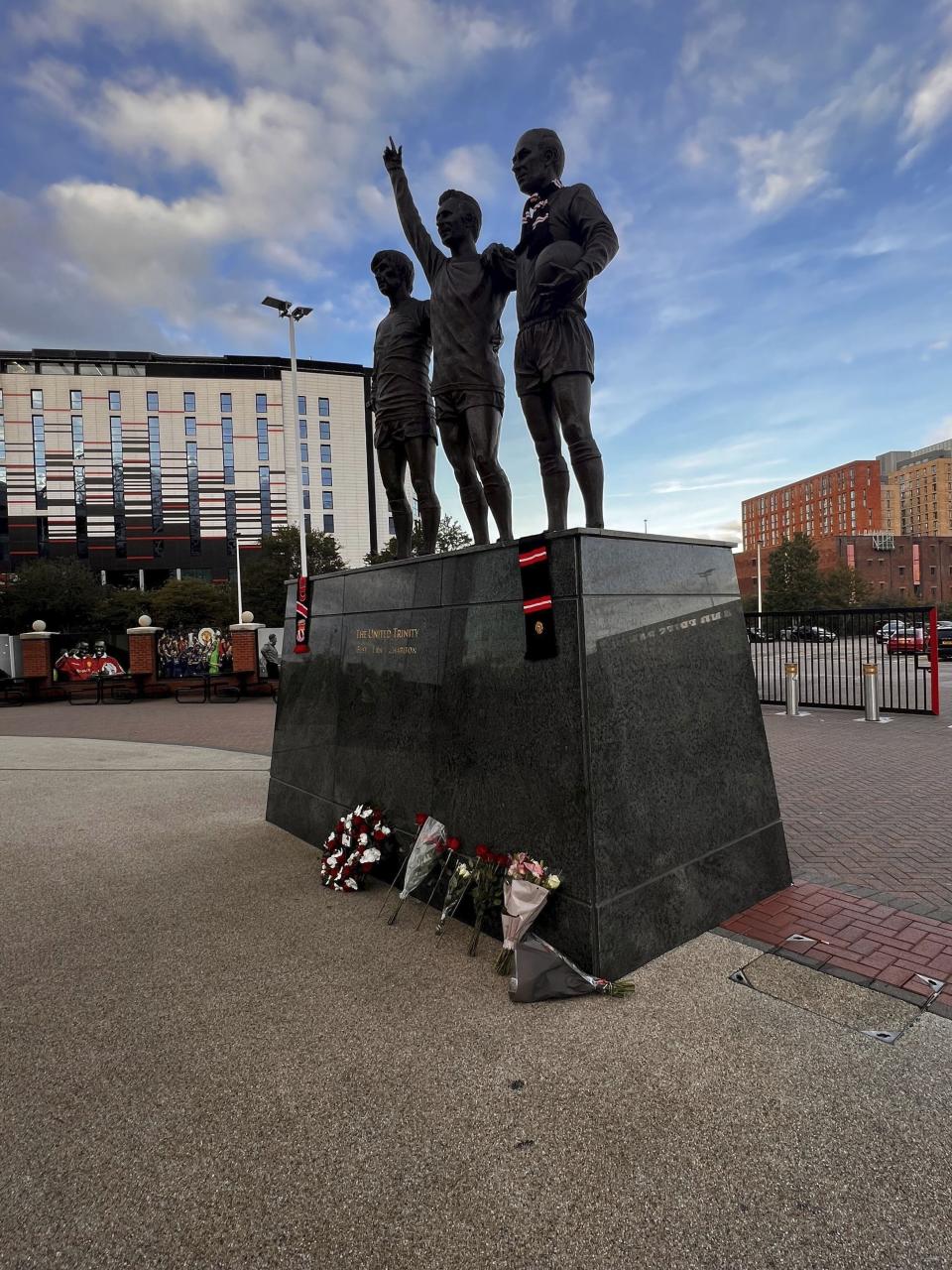 Tributes are laid in memory of Bobby Charlton by The United Trinity statue at Old Trafford, Manchester, England, Saturday, Oct. 21, 2023. Manchester United and England soccer great Bobby Charlton has died at the age of 86. He was an English soccer icon who survived a plane crash that decimated a United team destined for greatness to become the heartbeat of his country’s 1966 World Cup-winning team. A statement from Charlton’s family released by United says he died surrounded by his family. Charlton was an extravagantly gifted midfielder with a ferocious shot. (Steven Allen/PA via AP)