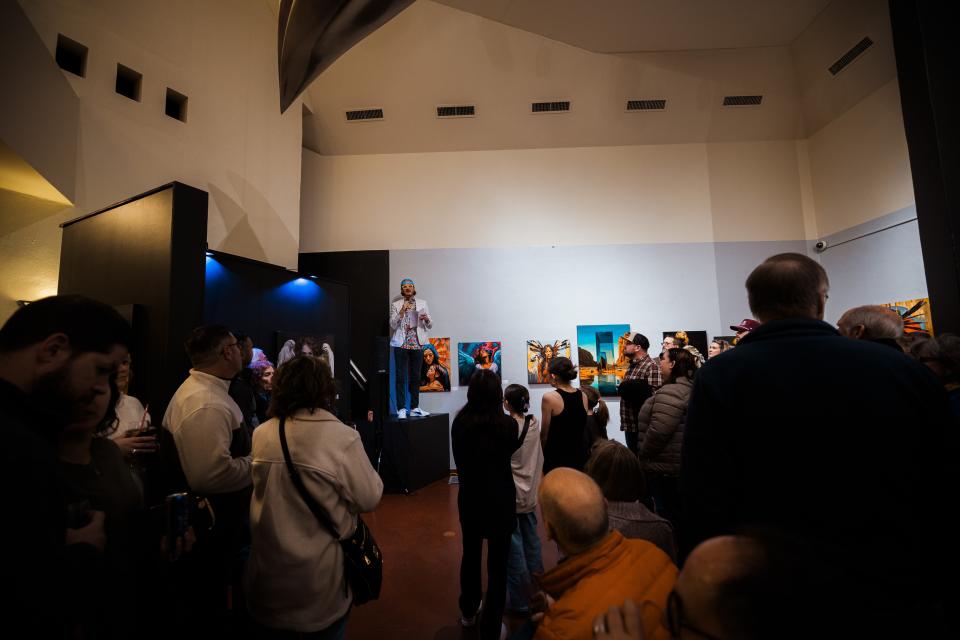 Artist Jon Lindblom addresses the packed crowd during opening night of his art exhibit, 'Angels of Pandora: An AI/Human Collaboration,' at Price Tower Jan. 19.