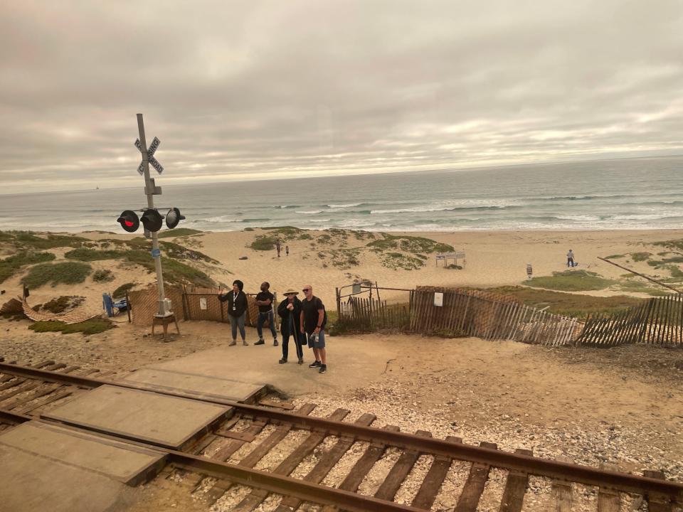 beach with train tracks and people waiting to cross