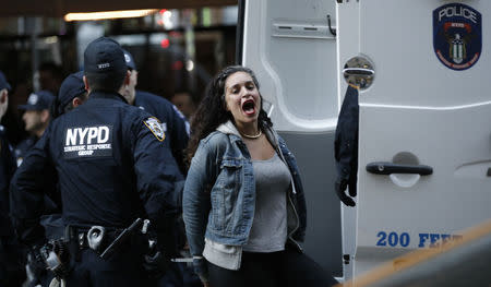 A demonstrator is loaded into a police van after being detained inside the venue of the 2016 New York State Republican Gala while protesting against Donald Trump in midtown Manhattan in New York City, April 14, 2016. REUTERS/Mike Segar