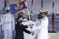 Taiwan's President Tsai Ing-wen, left, presents a flag during the commissioning ceremony of the the domestically made Ta Jiang warship at the Suao naval base in Yilan county, Taiwan, Thursday, Sept. 9, 2021. Taiwan's president oversaw the commissioning of a new domestically made navy warship Thursday as part of the island's plan to boost indigenous defense capacity amid heightened tensions with China. (AP Photo/Chiang Ying-ying)