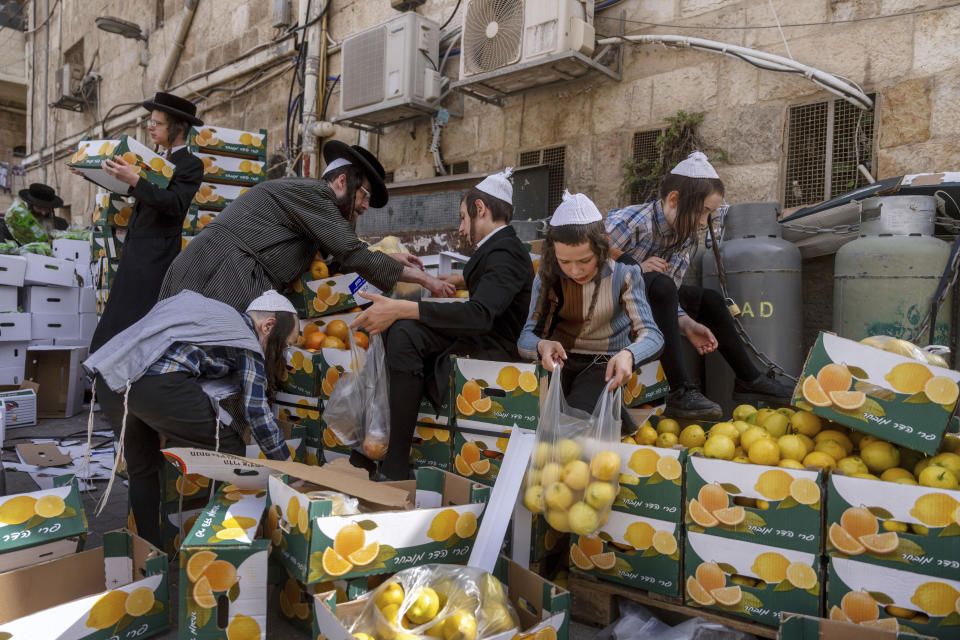 Ultra-Orthodox Jews collect food distributed to large families for free, in a special market ahead of the upcoming Passover holiday in Jerusalem, Thursday, April 18, 2024. Jews are forbidden to eat leavened foodstuffs during the Passover holiday that celebrates the biblical story of the Israelites' escape from slavery and exodus from Egypt. (AP Photo/Ohad Zwigenberg)