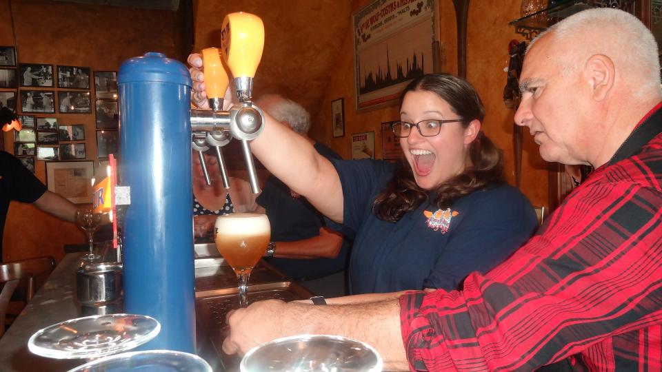 Jessica Maxon learns to serve beer from a tap at Malheur Brewery in Belgium.