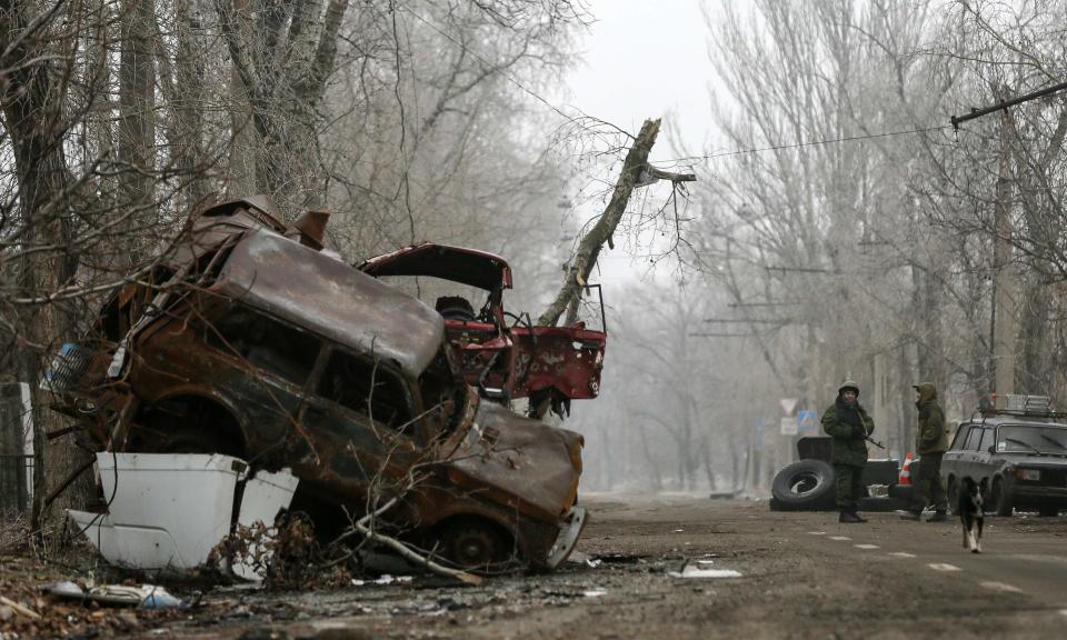 Pro-Russian separatists stand guard next to cars damaged during fighting between pro-Russian rebels and Ukrainian government forces near Donetsk Sergey Prokofiev International Airport, eastern Ukraine, December 16, 2014. REUTERS/Maxim Shemetov (UKRAINE - Tags: POLITICS CIVIL UNREST CONFLICT)