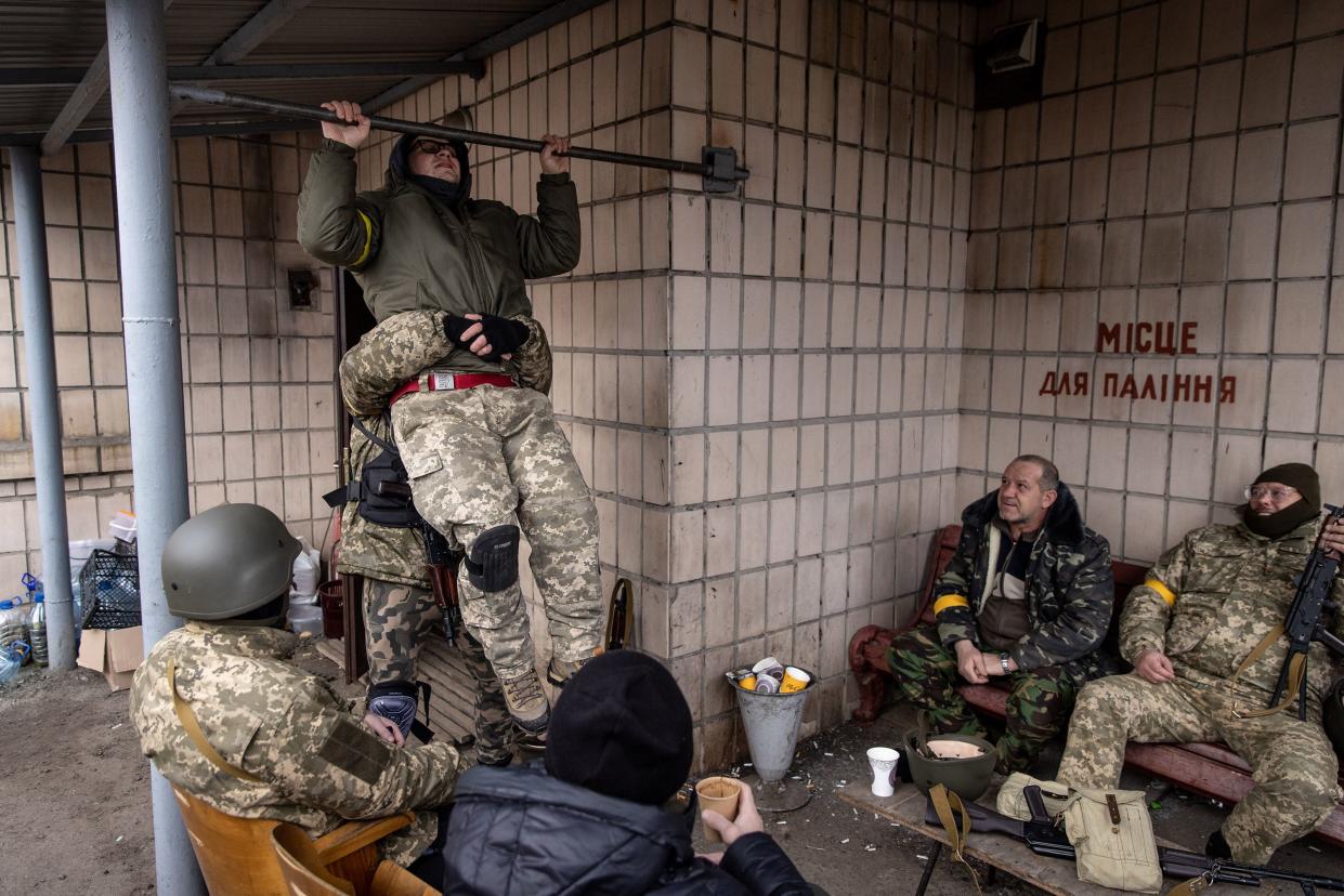 A member of a Territorial Defence unit does pull-ups before starting his shift guarding a barricade on the outskirts of eastern Kyiv on March 6, 2022, in Ukraine.