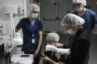 Medical staff talk through their face masks at a ward of COVID-19 patients at Infectious Hospital No. 23 in Nizhny Novgorod, Russia, on Wednesday, Oct. 20, 2021. The low vaccination rate in Russia, where only about a third of the population is fully vaccinated, is causing concern as the country suffers a sharp rise in cases, setting records for infections and deaths nearly every day this month. (AP Photo/Roman Yarovitcyn)