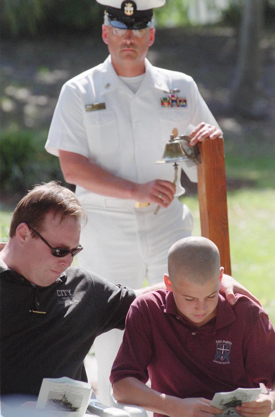 At the 2000 memorial gathering for the USS Stark, William Elliott tries to comfort his nephew Logan Pierce, 13, whose father, 1st Class Petty Officer Randy Pierce, was killed in the May 17, 1987, attack. Logan was born in April 1987 and never met his father.