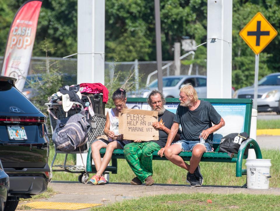 A person panhandles at the intersection of Beverly Parkway and North W Street in Escambia County on Monday, Sept. 11, 2023.