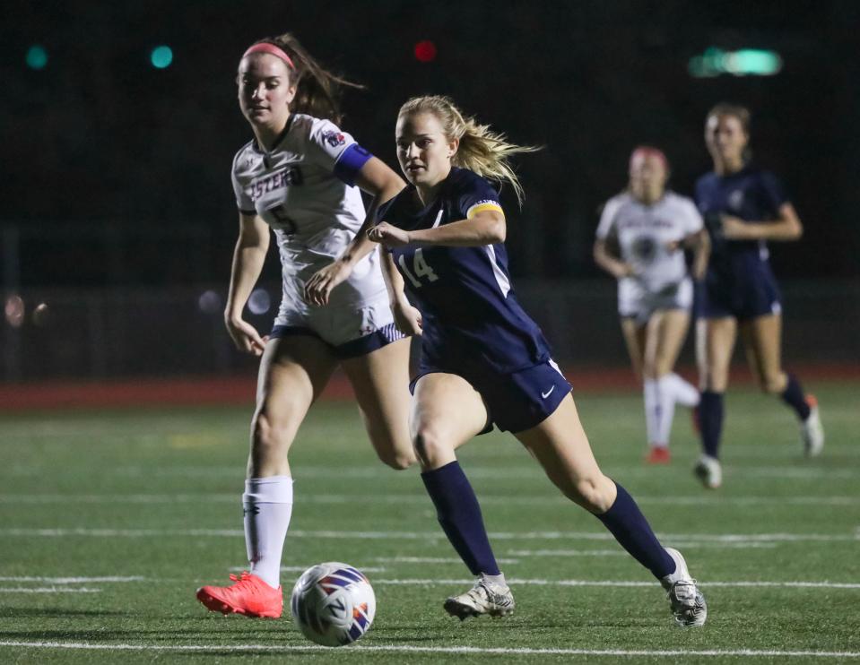 Naples Golden Eagles forward Elaina Loden (14) makes a run to the net while being guarded by Estero Wildcats defender Morgan King (5) during the first half of a game at Staver Field in Naples on Tuesday, Jan. 17, 2023. Loden had two goals for the Eagles.