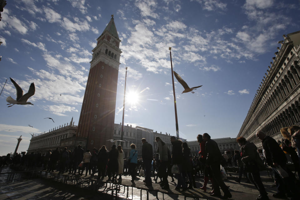 FILE - Tourists queue to enter St. Mark's Basilica in Venice, Italy, Nov. 12, 2016. Starting in January, Venice will oblige day-trippers to make reservations and pay a fee to visit the historic lagoon city. On many days, the heart of Venice is overwhelmed by visitors, who often far outnumber residents. Venice officials on Friday unveiled new rules for day-trippers, which go into effect on Jan. 16, 2023. (AP Photo/Luca Bruno, File)