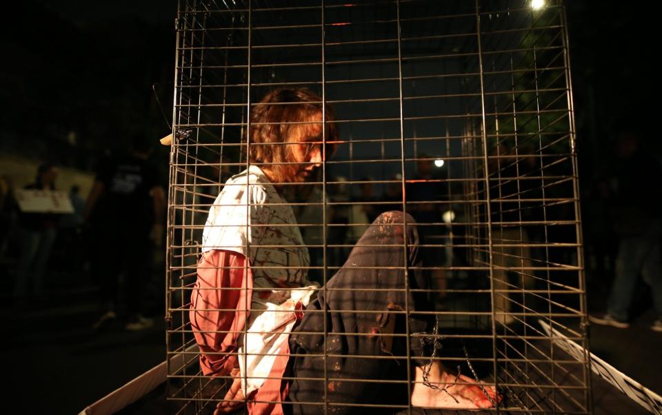 A citizen stood in a cage representing the prisoners as people gathered to demonstrate for the resignation of Prime Minister Benjamin Netanyahu's government