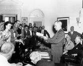 FILE - In this Aug. 14, 1945, file photo, President Harry S. Truman reads to newsmen his announcement of the Japanese surrender officially signaling the war's end during a White House, Washington. At the right of the President are Secretary of State James F. Byrnes and Admiral William D. Leahy, Presidential Chief of Staff. Emperor Hirohito, the grandfather of current Emperor Naruhito, announced Japan's surrender in a prerecorded radio message on Aug. 15, 1945. (AP Photo, File)