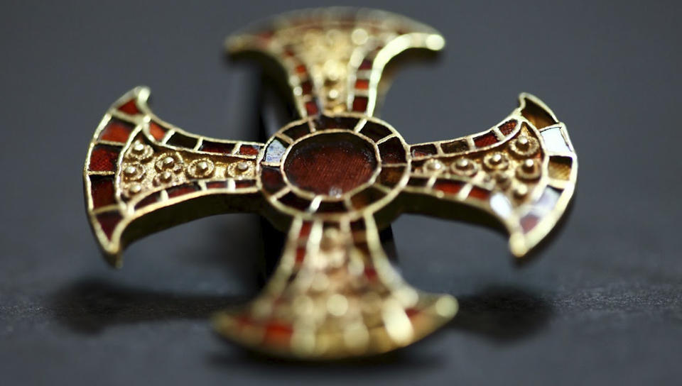 In this undated image made available by the University of Cambridge in England early Friday March 16, 2012, shows a cross. Archaeologists excavating near Cambridge have stumbled upon a rare and mysterious find, the skeleton of a 7th-Century teenager buried in an ornamental bed along with a gold-and-garnet cross, an iron knife and a purse of glass beads. There is very little known about this funerary practice, which one archaeologist, Alison Dickens, said would open a window of knowledge into the transitional period when the pagan Anglo-Saxons were gradually adopting Christianity. (AP Photo/University of Cambridge)