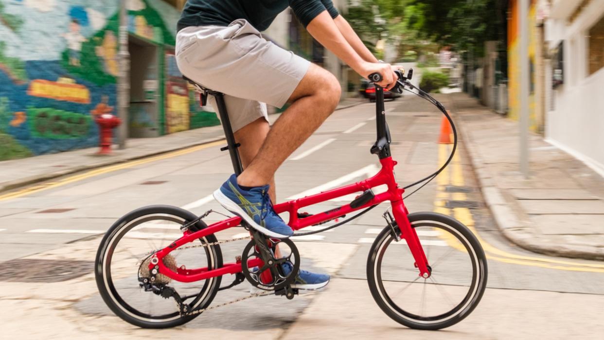  The Tern BYB P10 in red colour being ridden by a white male on a road  