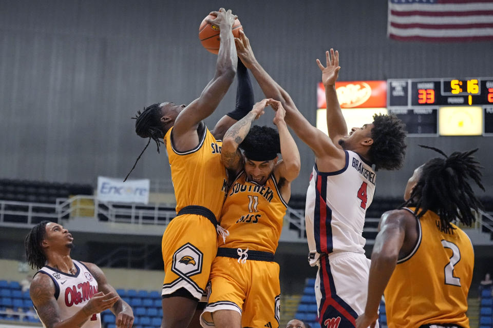 Southern Mississippi guard Andre Curbelo (11) ducks his head while forward Victor Iwuakor, top left, battles Mississippi forward Jaemyn Brakefield (4) for the ball during the first half of an NCAA college basketball game, Saturday, Dec. 23, 2023, in Biloxi, Miss. (AP Photo/Rogelio V. Solis)