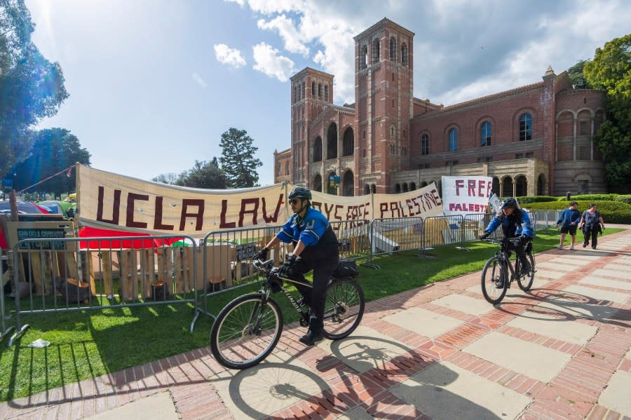 UCLA campus police cycle around the perimeter of a pro-Palestinian encampment on the UCLA campus Friday, April 26, 2024, in Los Angeles. As the death toll mounts in the war in Gaza and the humanitarian crisis worsens, protesters at universities across the country are demanding schools cut financial ties to Israel and divest from companies they say are enabling the conflict. (AP Photo/Damian Dovarganes)