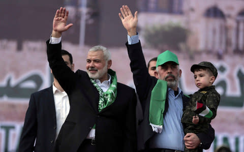 Head of the Hamas political bureau, Ismail Haniyeh, left, and Hamas leader in the Gaza Strip Yahya Sinwar, wave during a rally. - Credit: AP Photo/ Khalil Hamra