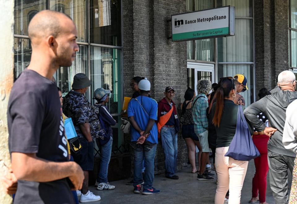 Cubans queue outside a bank in Havana on December 20, 2023. Cuba's economy will shrink by up to 2% this year, Finance Minister Alejandro Gil estimated on Wednesday, after acknowledging that the country will not be able to achieve the projected economic growth of 3% by 2023