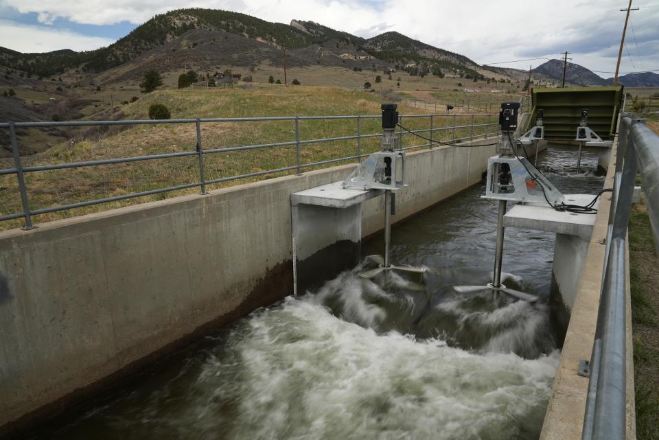 Water flows through an irrigation canal with a turbine at Ralston Reservoir in Arvada Colo. on Thursday, April 13, 2023. Emrgy, a business that places small turbines in irrigation canals to generate electricity, has raised $18.4 million to scale up its technology and generate carbon-free hydropower. (AP Photo/Brittany Peterson)