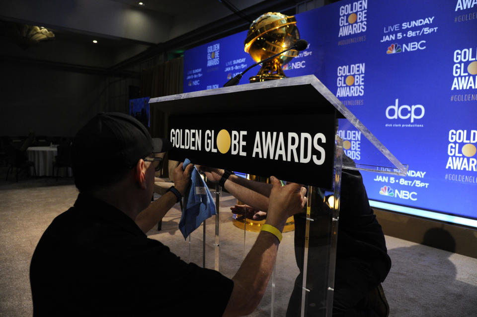 Staff members prepare the podium at the nominations for the 77th annual Golden Globe Awards at the Beverly Hilton Hotel on Monday, Dec. 9, 2019, in Beverly Hills, Calif. The 77th annual Golden Globe Awards will be held on Sunday, Jan. 5, 2020. (AP Photo/Chris Pizzello)