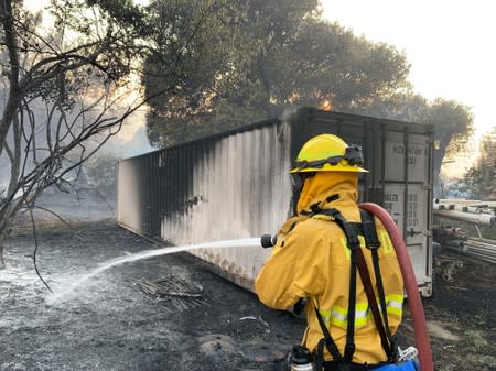 A fireman puts out flames from the Sand Fire in the Capay Valley in California