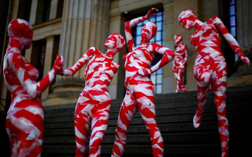 Mannequins wrapped in red and white barricade tape to symbolize the coronavirus disease crisis are placed at the Gendarmenmarkt square - REUTERS/Joachim Herrmann