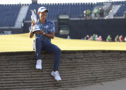 United States' Collin Morikawa holds up the claret jug trophy as he poses for photographers on the 18th green after winning the British Open Golf Championship at Royal St George's golf course Sandwich, England, Sunday, July 18, 2021. (AP Photo/Ian Walton)