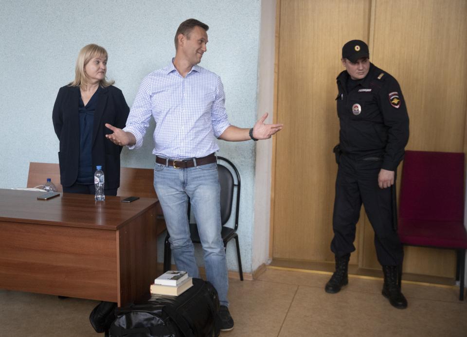 Russian opposition activist Alexei Navalny, center, gestures in a court before a hearing in Moscow, Russia, Monday, July 1, 2019. A Moscow court jailed Russian opposition leader Alexei Navalny for 10 days on Monday after finding him guilty of breaking the law when he took part in a street demonstration last month. (AP Photo/Pavel Golovkin)