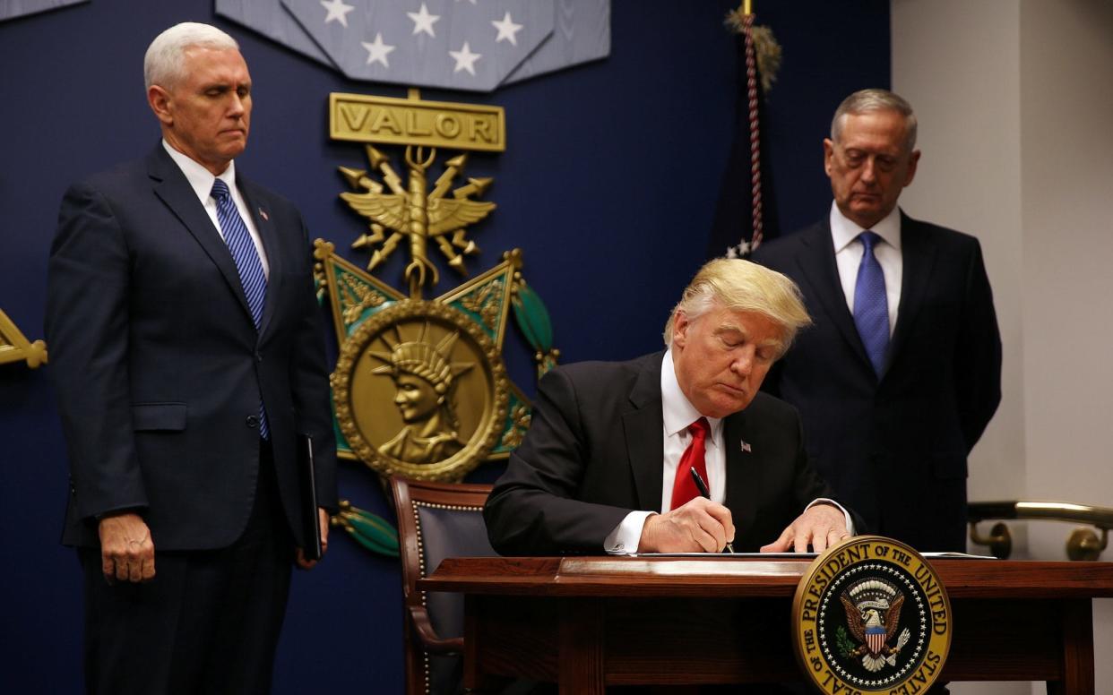 Donald Trump signs a revised executive order for a US travel ban on January 27, leaving Iraq off the list of targeted countries