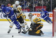 Pittsburgh Penguins goaltender Tristan Jarry (35) makes a save as Toronto Maple Leafs forward Auston Matthews (34) is hit by Penguins defenseman Kris Letang (58) during the second period of an NHL hockey game Thursday, Feb. 17, 2022, in Toronto. (Nathan Denette/The Canadian Press via AP)