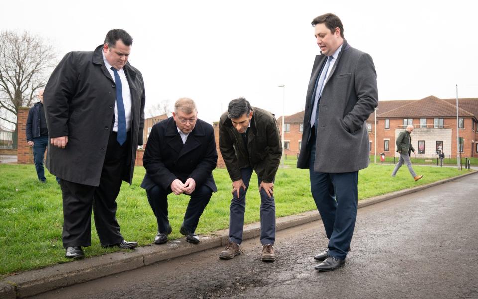 Rishi Sunak inspects pothole during a visit to Darlington this morning. The Prime Minister is pictured with Darlington Council leader Jonathan Dulston (far left), Tees Valley Mayor Ben Houchen (far right) and Darlington MP Peter Gibson (second from left) - Stefan Rousseau/PA