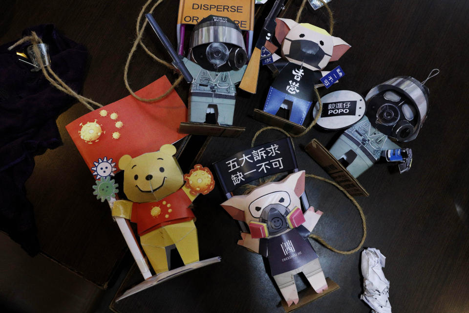 Paper figures of police officers, protesters and Winnie the Pooh, with messages in support of the pro-democracy movement are removed at a restaurant in Hong Kong, Thursday, July 2, 2020. Hong Kong police have made the first arrests under a new national security law imposed by mainland China, as thousands of people defied tear gas and pepper pellets to protest against it. Police say they arrested 10 people under the law, including at least one who was carrying a Hong Kong independence flag. (AP Photo/Kin Cheung)