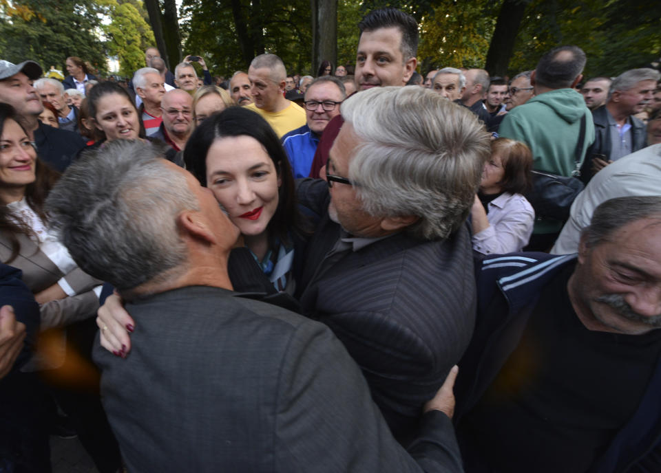 Protesters kiss opposition candidate Jelena Trivic during protest against alleged election fraud in a general elections in the Bosnian town of Banja Luka, 240 kms northwest of Sarajevo, Thursday, Oct. 6, 2022. Opposition parties asking to open the bags and recount the votes for the President of Republika Srpska. (AP Photo/Radivoje Pavicic)