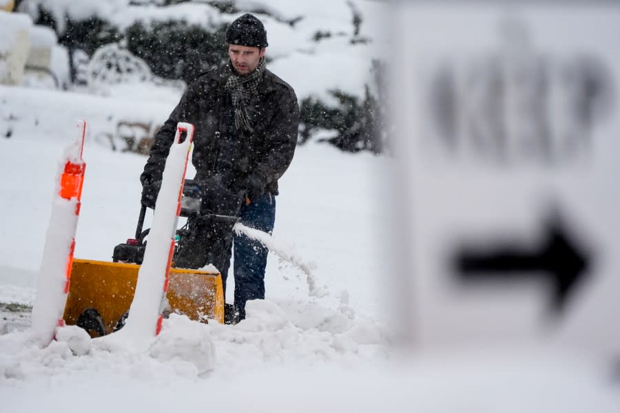 A man clears a sidewalk as a winter storm arrives Friday, Jan. 12, 2024, in Milwaukee. (AP Photo/Morry Gash)