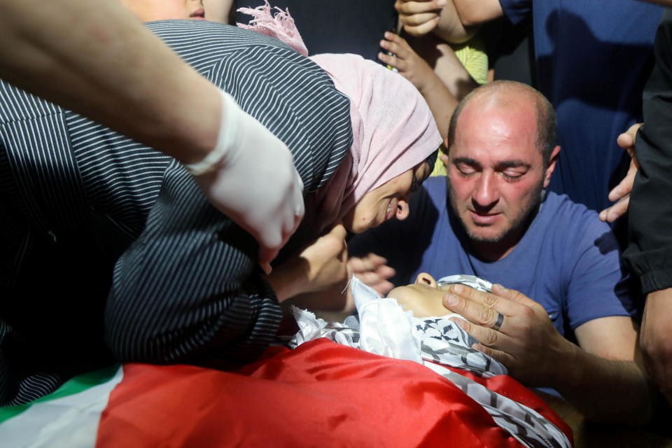 Parents mourn over the body of their son Ghaith Yamen, a Palestinian teen who was killed during clashes with Israeli forces, during his funeral in Nablus, in the Israeli-occupied West Bank, May 25, 2022. / Credit: RANEEN SAWAFTA/REUTERS