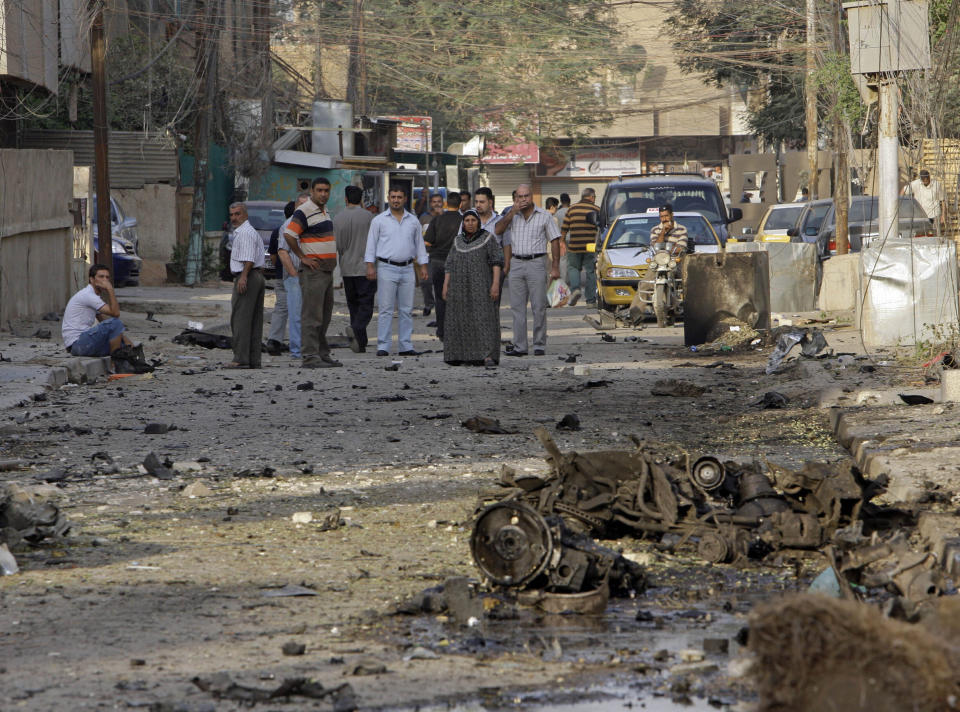 File - In this Monday Nov. 1, 2010 file photo, Iraqis inspect the scene of a car bomb attack in front of a Our Lady of Salvation Church in Baghdad, in Baghdad, Iraq. Islamic militants held around 120 Iraqi Christians hostage for nearly four hours in a church Sunday before security forces stormed the building and freed them, ending a standoff that left dozens of people dead, U.S. and Iraqi officials said. (AP Photo/Khalid Mohammed, File)