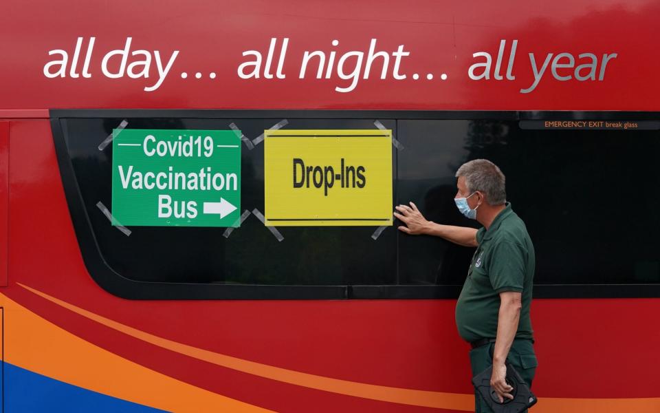 In Scotland, paramedic Dougie Blues puts signs on a vaccination bus in the car park of Crieff Community Hospital - Andrew Milligan/ PA 