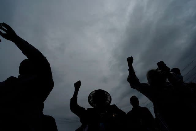 <p>AP Photo/John Locher</p> People raise up their arms during the dedication of a prayer wall outside of the historic Vernon African Methodist Episcopal Church in the Greenwood neighborhood during the centennial of the Tulsa Race Massacre in 2021.