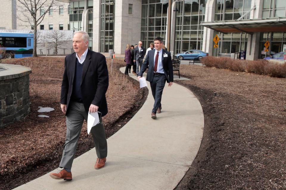 UVM Health Network CEO Dr. John Brumsted, left, leads a group of medical professionals outside of the hospital to a news conference regarding a patient being treated for COVID-19 at the University of Vermont Medical Center on March 12, 2020.