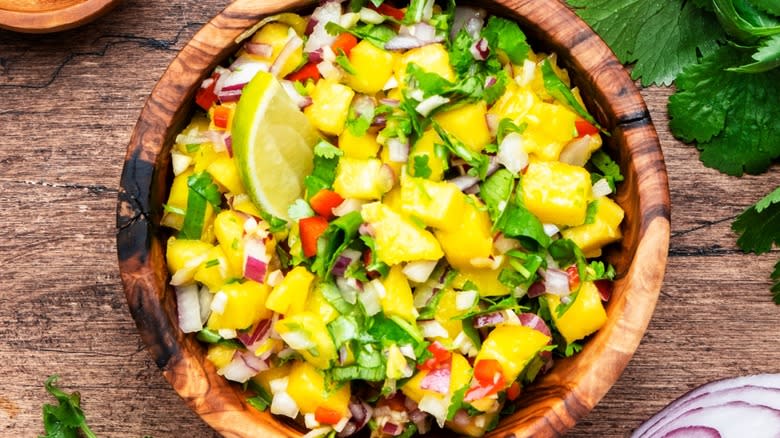 Top-down view of fresh mango and cilantro salsa in a wooden bowl