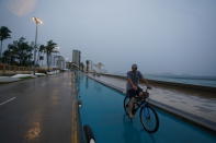 A cyclist rides along the coast in Mazatlan, Mexico, early Monday, Oct. 3, 2022, as Hurricane Orlene approaches. The storm is heading for Mexico's northwest Pacific coast between Mazatlan and San Blas. (AP Photo/Fernando Llano)