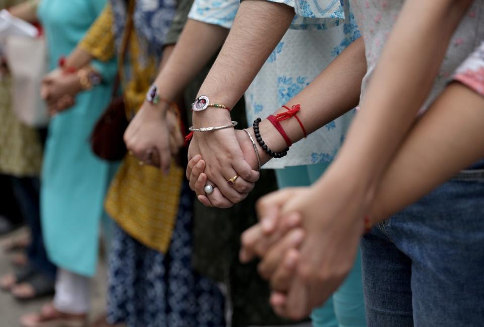 Medical students and doctors make a human chain during a protest as they demand justice (EPA)