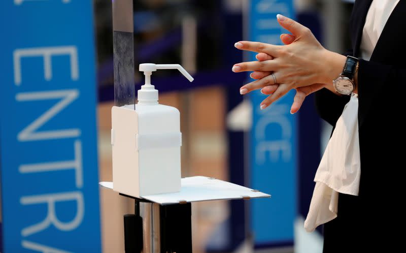A woman rubs her hands with sanitizer at a check-in counter amid the coronavirus disease (COVID-19) outbreak at Haneda airport in Tokyo
