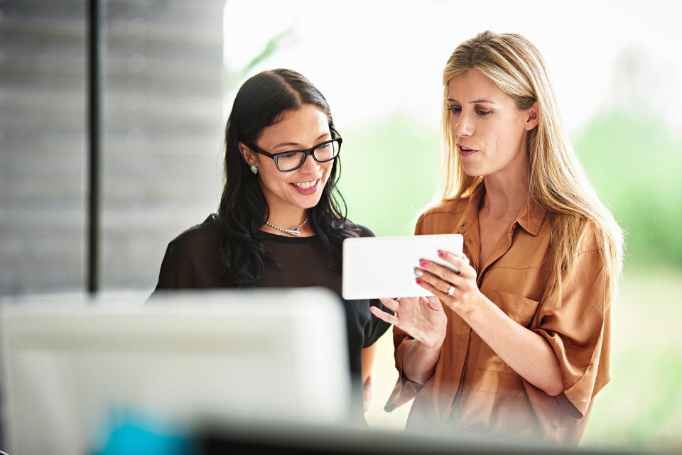 Businesswomen discussing plans on a digital tablet