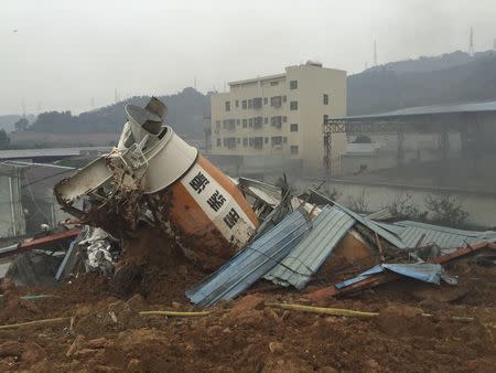 A damaged vehicle is seen among the debris at the site of a landslide at an industrial park in Shenzhen, Guangdong province, China, December 20, 2015. REUTERS/Stringer