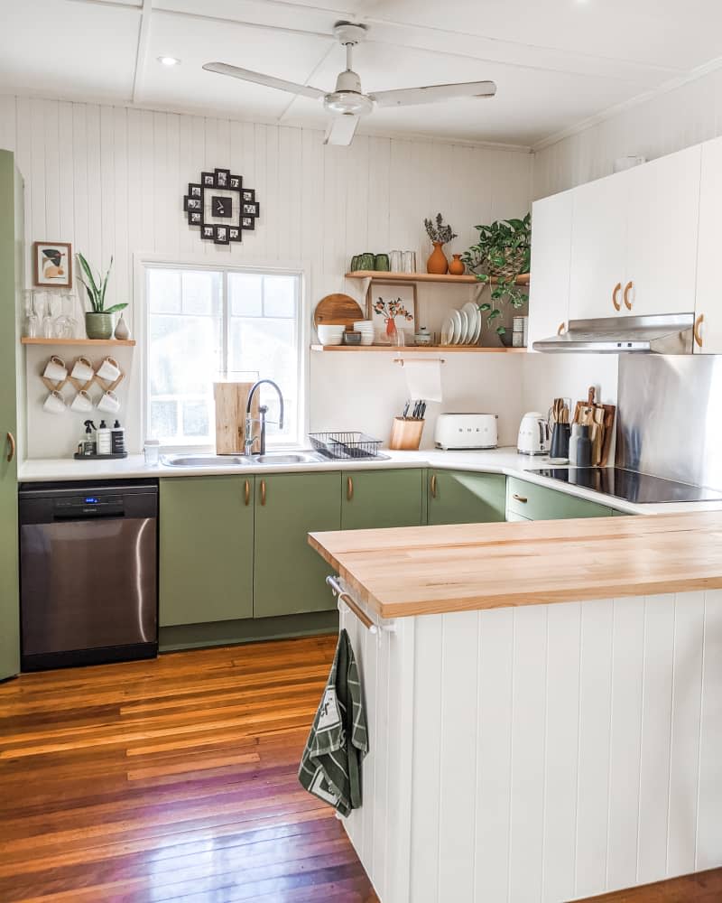 Green and white kitchen with peninsula.