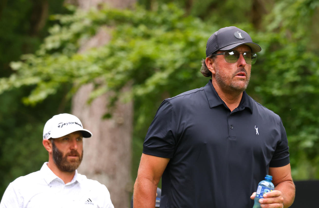 ST ALBANS, ENGLAND - JUNE 09: Dustin Johnson of 4 Aces GC greets Phil Mickelson of Hy Flyers GC look on from the 4th tee during day one of the LIV Golf Invitational - London at The Centurion Club on June 09, 2022 in St Albans, England. (Photo by Chris Trotman/LIV Golf/Getty Images)