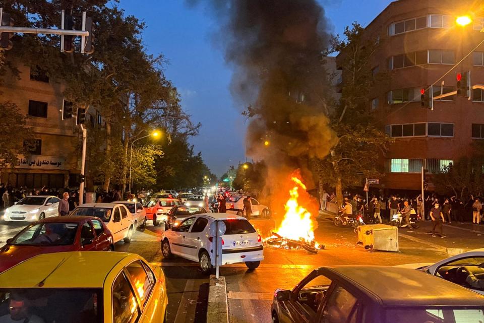 A police motorcycle burns during a protest in Iran (via REUTERS)