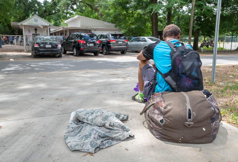 A man sits outside the Alfred Washburn Center in Pensacola on Wednesday, April 26, 2023.