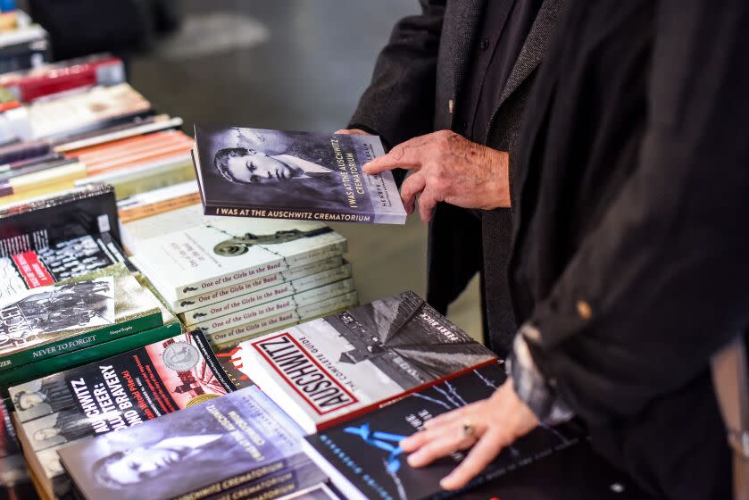 Ralph Hakman browsed a display of books about the Holocaust on a shelf at the Jewish museum and cultural center in Krakow, Galicia Museum,